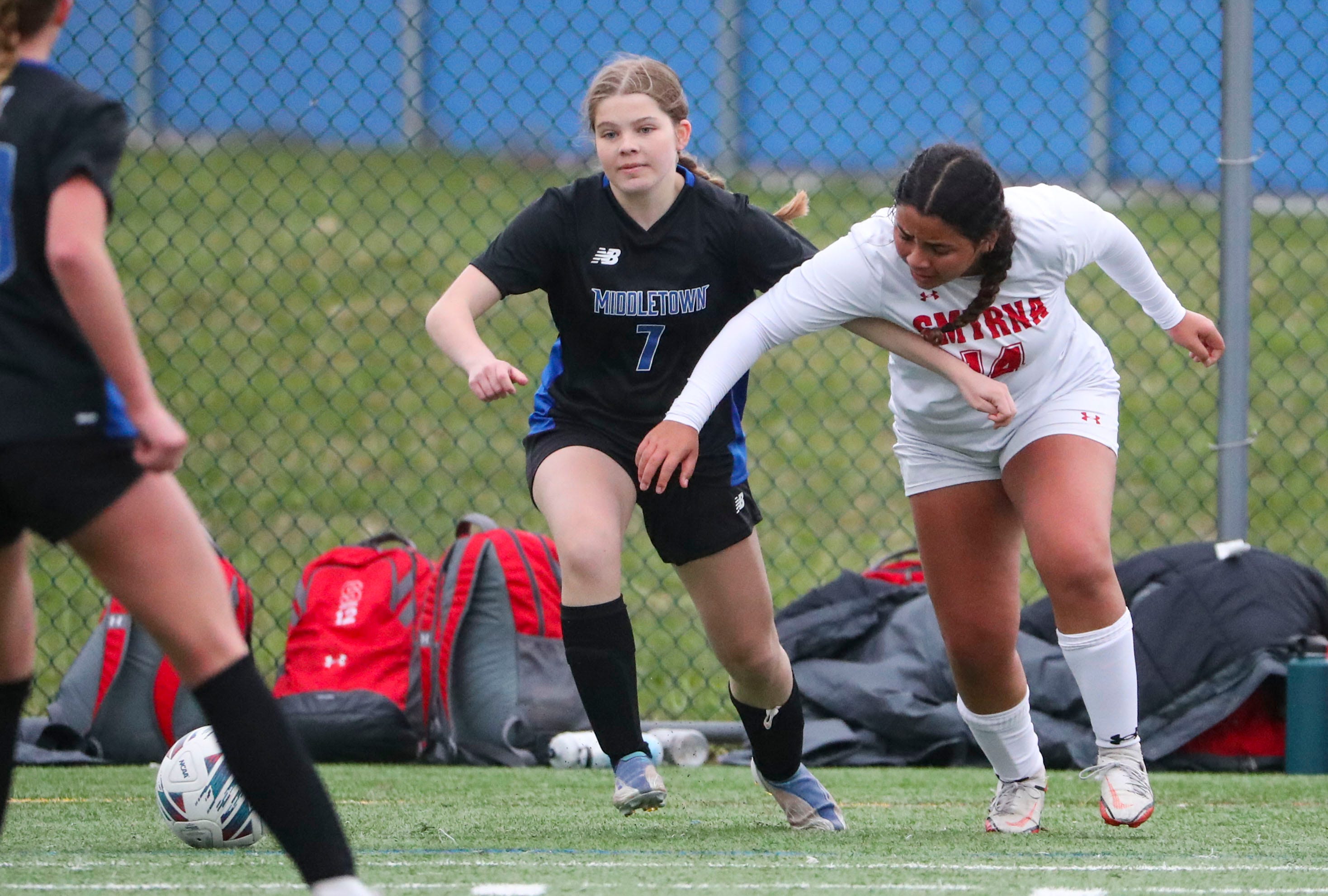 Middletown's Drew Cimo (left) tries to move past Smyrna's Jocelyn Tejeda in the second half of the Cavaliers' 5-0 win at Middletown, Thursday, March 28, 2024.